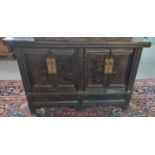 Chinese black painted sideboard, the moulded top above four blind panelled doors with metal locks