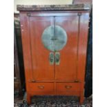 Chinese red finished blind panelled two door cupboard, having gilded and pierced frieze, over the