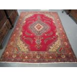 Middle Eastern design Tabriz carpet on a red ground, the borders with multi-coloured geometric