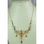 A late Victorian amethyst and seed pearl necklace set in 9ct gold. With safety chain. Length 16