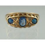 18ct gold sapphire and diamond ring. The three sapphires interspersed by diamond points. Ring size