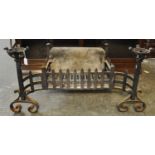 Medieval style wrought iron fire basket with incorporated scrolled andirons and candle holders