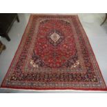 Middle Eastern design Kashan carpet on a multi-coloured stylised flower head and foliage design, the