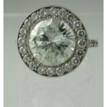 A diamond halo ring. The centre stone an estimated 5cts surrounded by brilliant cut diamonds with