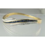 An 18ct gold sapphire and diamond half hinged bangle. Approx weight 23.6 grams. (B.P. 21% + VAT)