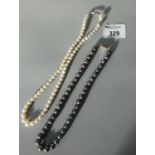 A string of cultured pearls and a string of cultured black pearls. (B.P. 21% + VAT)