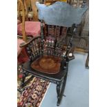 Early 20th Century American stained and carved spindle backed rocking chair with open arms and