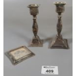 Pair of silver candlesticks with loaded bases in distressed condition. (B.P. 21% + VAT)