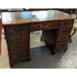 Reproduction mahogany knee hole desk having leather inset top above a bank of three drawers to