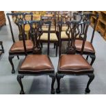 A set of four Chippendale style mahogany dining chairs with drop in seats standing on carved