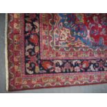 Middle Eastern design Mashad carpet on a mainly red ground with multi-coloured stylised floral and