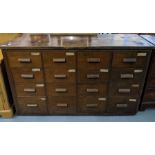 A set of mahogany storage drawers, possibly a shop fitting, having an arrangement of 24 short