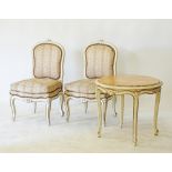 A pair of Louis XV style nursing chairs and a round table