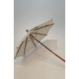 An Oriental antique folding cream silk parasol