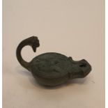 A Roman bronze oil lamp with animal head finial to the handle and impressed design