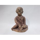 A Terracotta Figure Depicting a Man with Multiple Necklaces Sitting down Holding a Flower