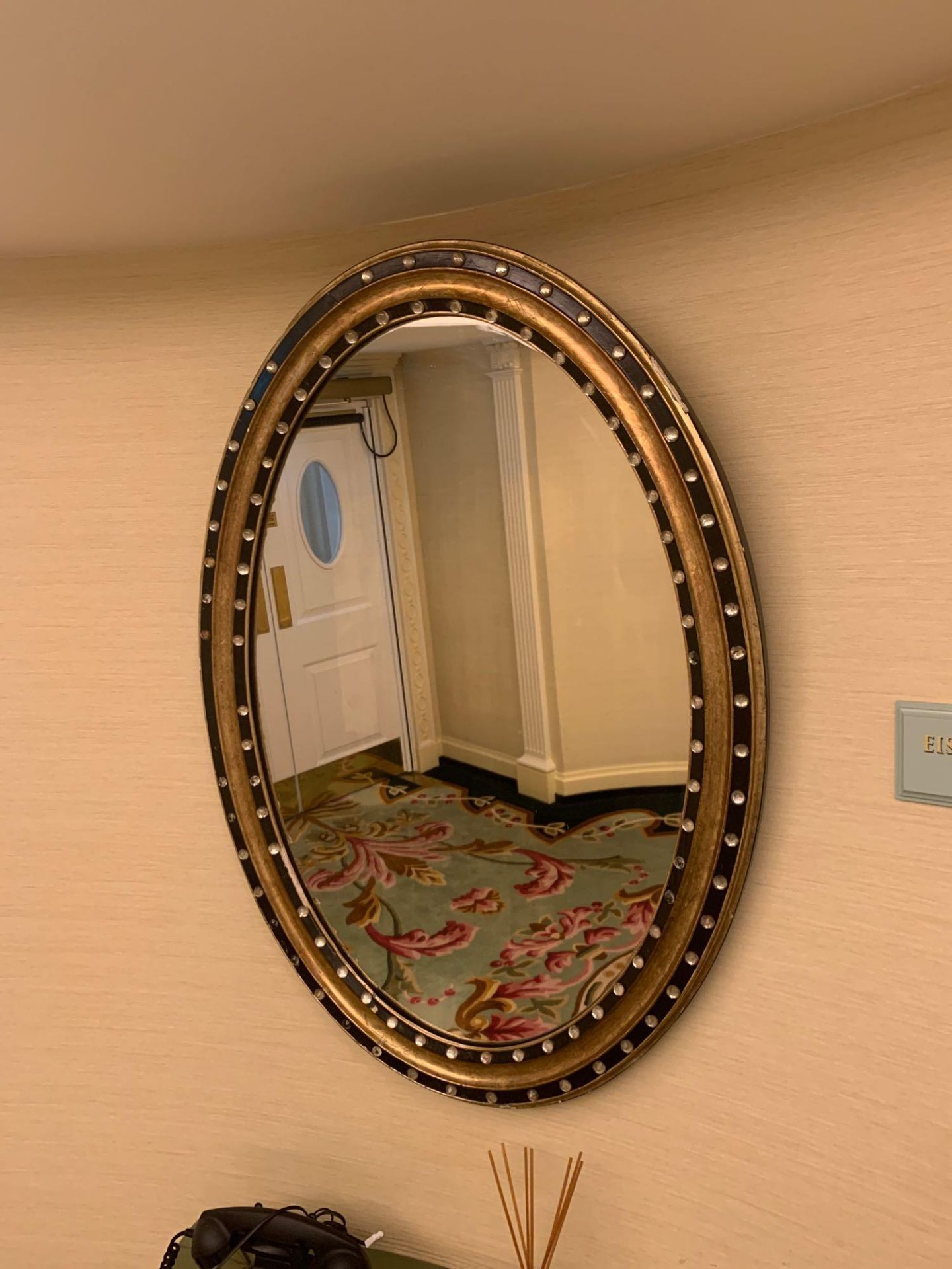 An Ovoid Form Mirror Featuring A Regency Design Of A Moulded Ebonized And Giltwood Frame With