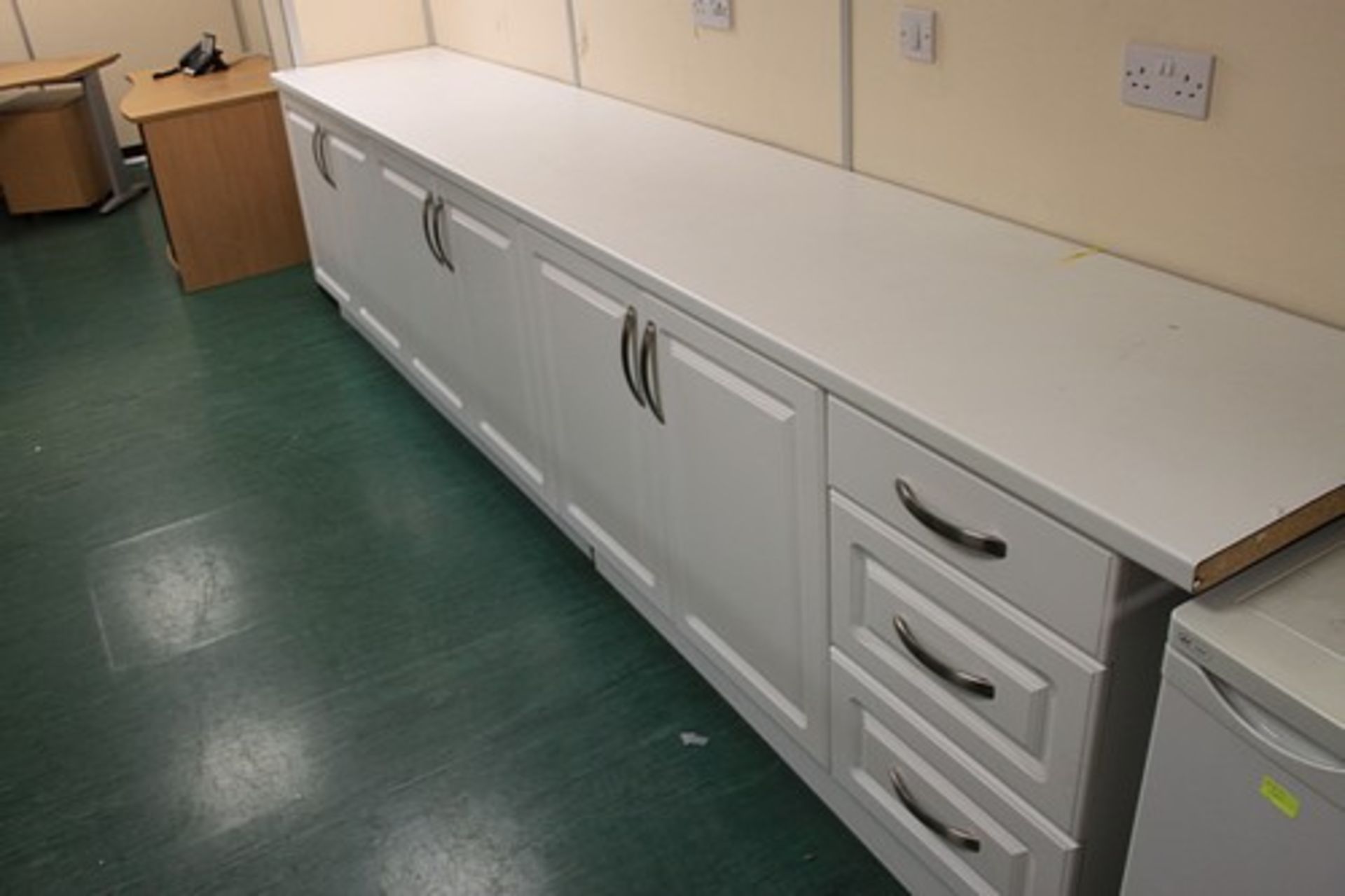 White melamine glossed base cabinets comprising 3 x double door cupboards and a three drawer