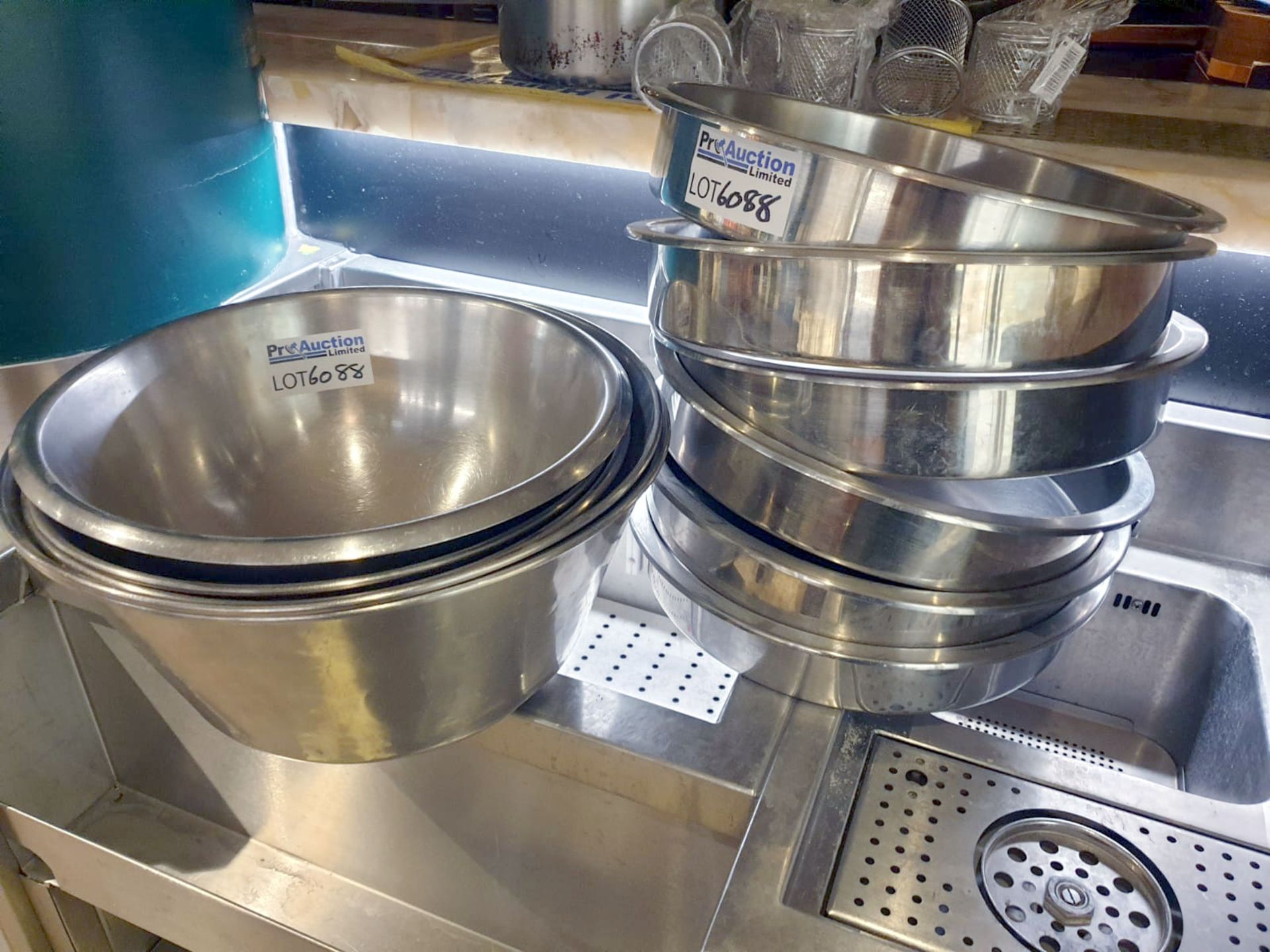 A quantity of large stainless steel bowls as lotted