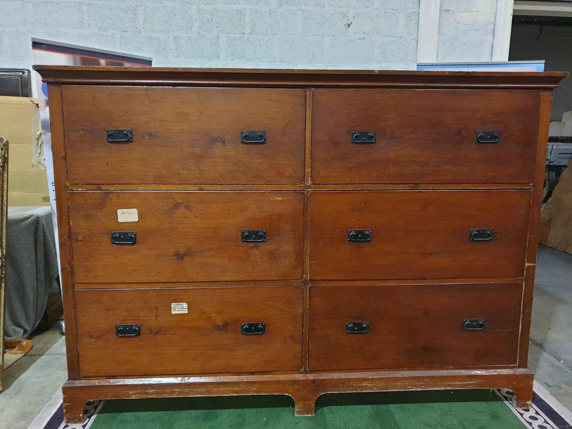 A large late Victorian stained pine chest of drawers. With two banks of three deep drawers, each