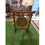 An Oriental brass gong on wooden stand An oriental, possibly Chinese circular hammered brass gong on