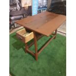 Stained wooden folding two-leaf table on tapering legs joined by a plain rail and having a drawer