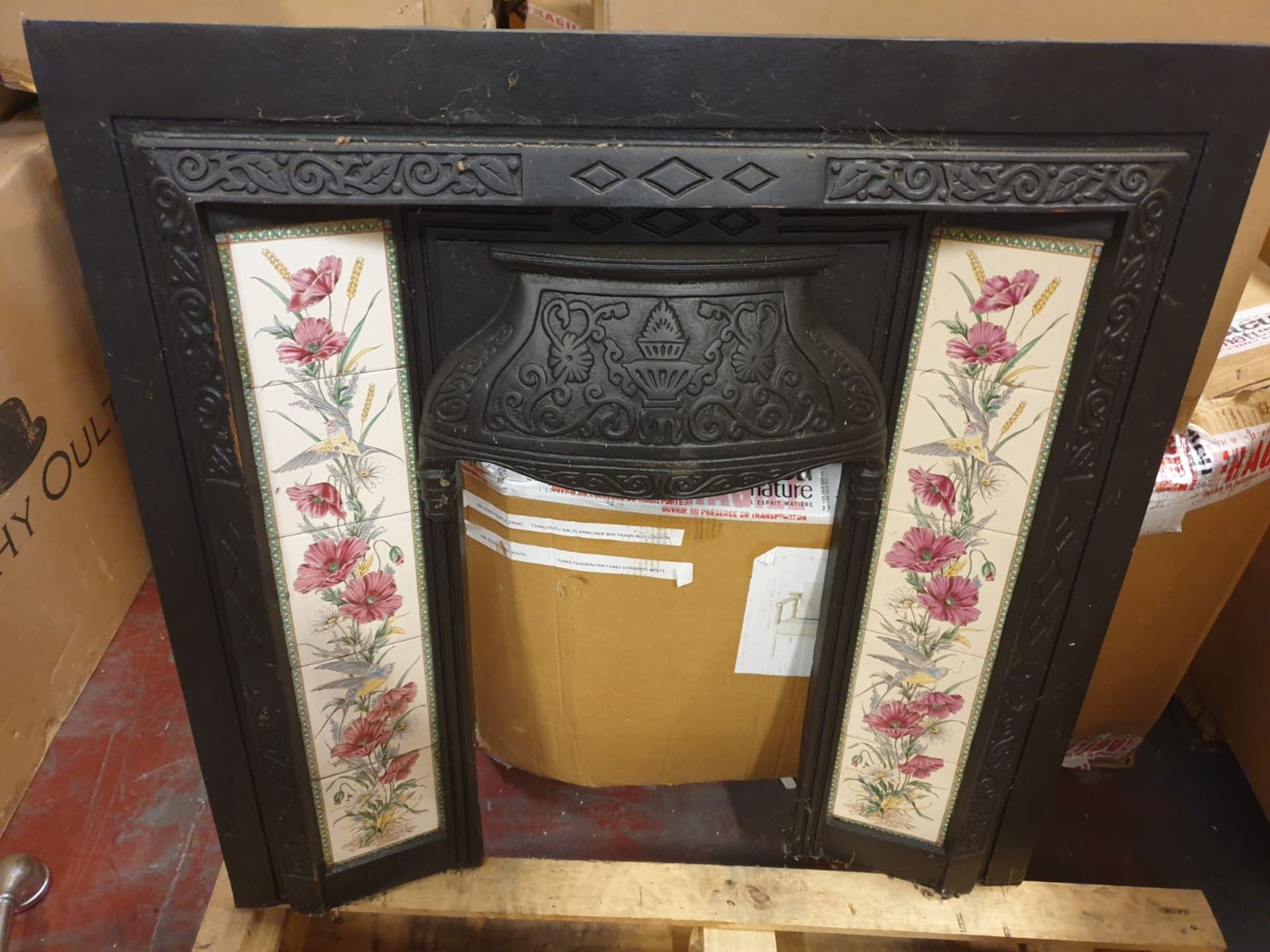 A Victorian Style cast iron black fire surround decorated with Poppy & Wheatsheaf ceramic tiles with