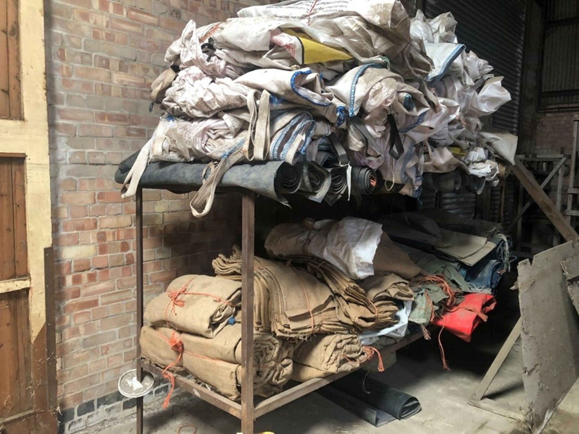 Angle iron rack and contents of hessian sacks, Hovis floor mats, seed corn bags