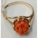 AN OVAL CARVED CORAL RING SET IN 9ct