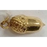 A GOLD ACORN SHAPED CHARM