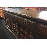 LARGE CARVED YOUNGER SIDEBOARD, 4 CUPBOARDS, 3 DRAWERS & BRASS DROP HANDLES (6ft 9'' L)