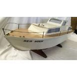 WHITE MODEL BOAT ON A STAND CALLED SEA NOOK