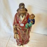 RED GLAZED CLAY FIGURE OF A CHINA MAN HOLDING A CHILD A/F