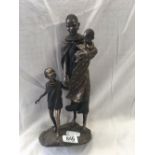 A RESIN FIGURE OF A MESSI GRANDMOTHER HOLDING CHILDREN