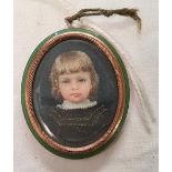 AN OVAL PORTRAIT MINIATURE OF A YOUNG CHILD. IN A GILT AND GREEN ENAMEL FRAME WITH INSCRIPTION TO