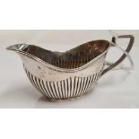 A VICTORIAN HALF FLUTED SILVER CREAM JUG, B'HAM 1898