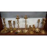 SHELF OF BRASS WARE, MAINLY CANDLESTICKS