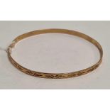 A 9ct ENGRAVED GOLD BANGLE WITH ENGRAVED DECORATION, 5.3g