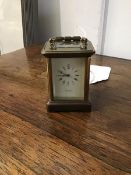 A miniature brass four glass carriage clock with white enamel dial and roman numerals, marked