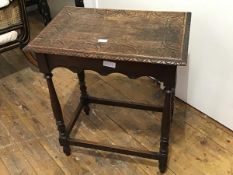 An Edwardian oak side table, the rectangular top with carved border and moulded edge, scalloped