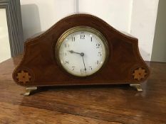 An Edwardian mahogany inlaid mantel clock of dome shape, with white enamel dial and arabic numerals,