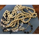 A collection of paste pearls and white metal necklaces.