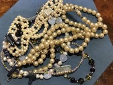 A collection of paste pearls and white metal necklaces.
