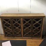 An Indian hardwood bookcase, with limed finish, the rectangular top with moulded edge above four