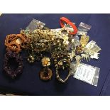 A bag containing a mixed lot of beads, pendants, brooches, earrings etc. (a lot)