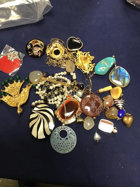 A mixed lot of jewellery comprising pendants and brooches, including mother of pearl, jade etc. (a