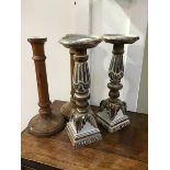 A pair of carved limed oak candlesticks, the circular tops on turned and fluted columns and square