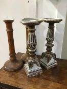 A pair of carved limed oak candlesticks, the circular tops on turned and fluted columns and square