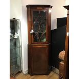 A late 19thc mahogany standing corner cabinet, the projecting cornice above a glazed astragal