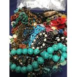 A bag containing a mixed lot of beads and pendants including turquoise, polished stones, mother of